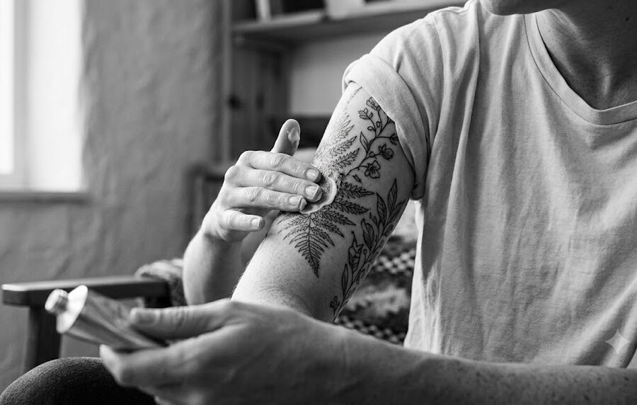 Why is my tattoo itchy? Person touching a healing upper-arm tattoo