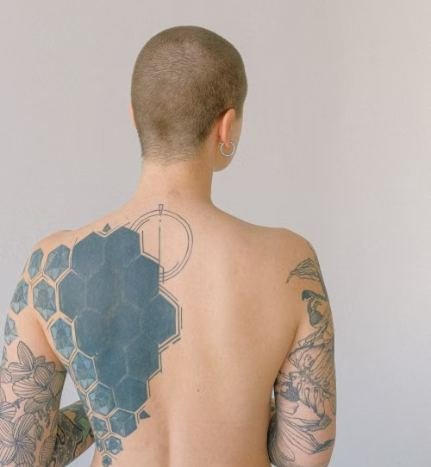Close-up of a blackwork tattoo style design showing solid black ink and geometric patterns on skin