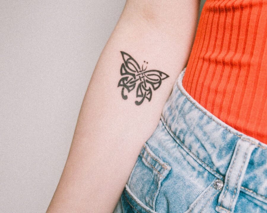 Close-up of a butterfly tattoo on a woman’s arm, a design rich in meaning and symbolism