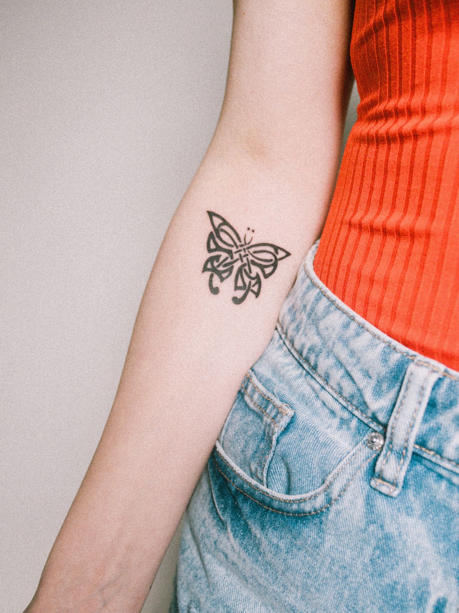 Close-up of a butterfly tattoo on a woman’s arm, a design rich in meaning and symbolism