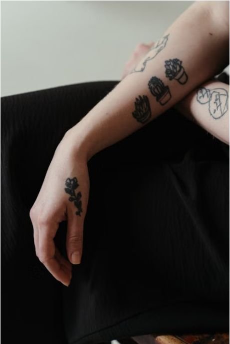 Close-up of a small rose tattoo on the back of a hand