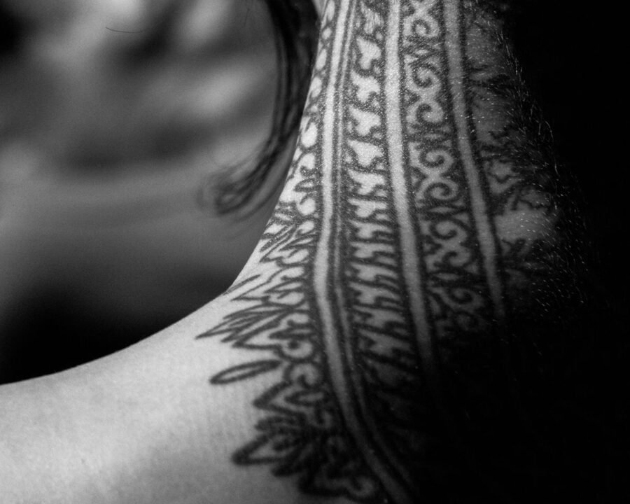 Close-up of a neck tattoo, an area associated with neck tattoo pain in the High band