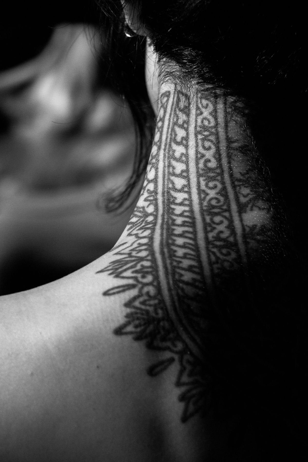 Close-up of a neck tattoo, an area associated with neck tattoo pain in the High band