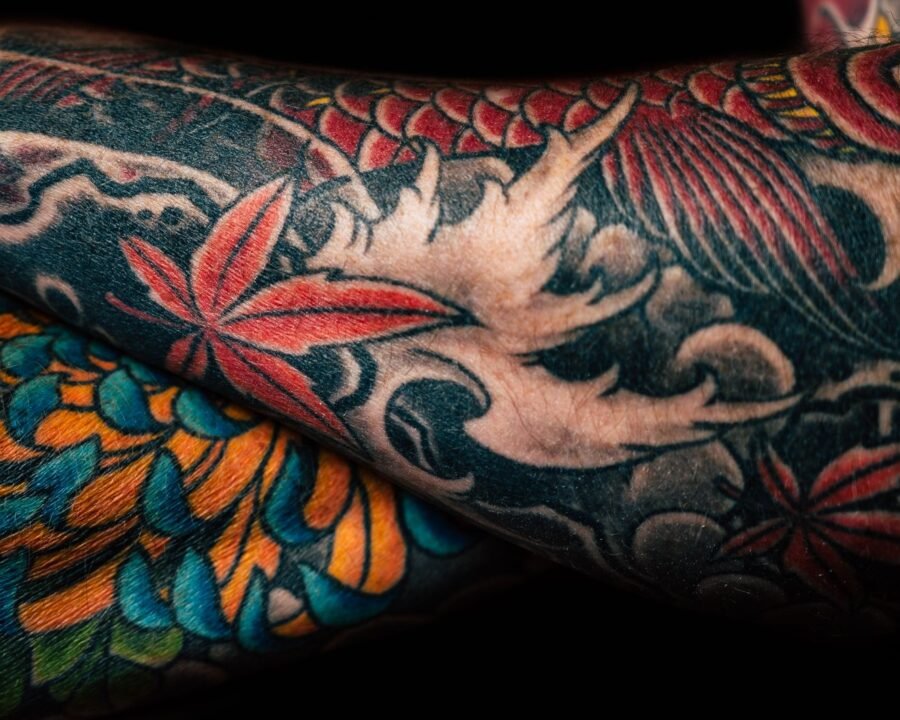 Colorful neo traditional tattoo sleeve with floral detail and bold structural lines