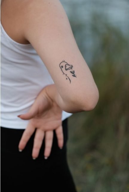 Small tattoo placement ideas — small minimalist tattoo on a person's upper arm, an example of a placement that ages well