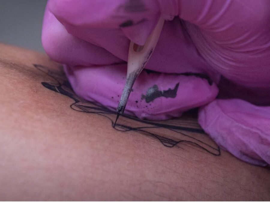 Tattoo blowout — close-up of a tattoo needle working on thin skin, illustrating how tattoo blowout can occur