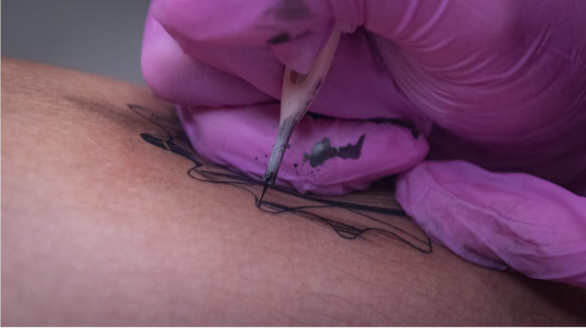 Tattoo blowout — close-up of a tattoo needle working on thin skin, illustrating how tattoo blowout can occur